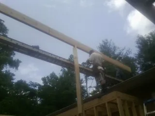 Carpenter setting a ridge beam over a new addition frame — Ice Dam Removal by Roofing Brothers in Ulm