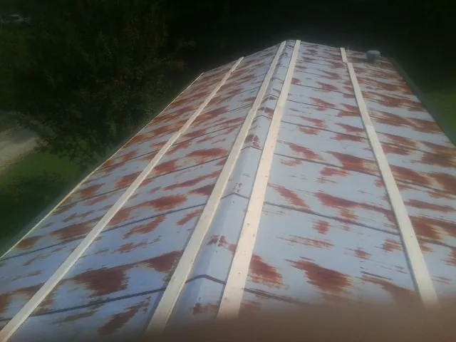 Rusted metal roof panels with new wood purlins before replacement — Storm Damage Roof Repair in Ulm by Roofing Brothers